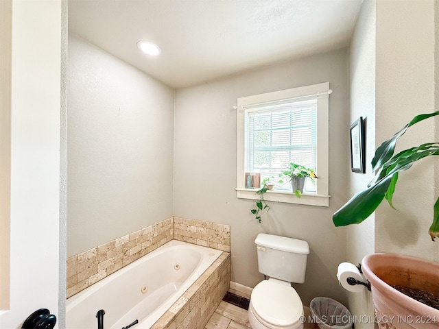 bathroom with tiled tub and toilet