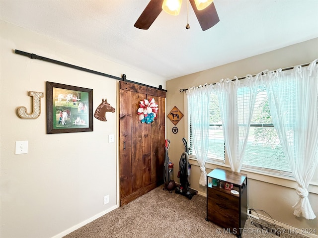 miscellaneous room featuring a barn door, light colored carpet, and ceiling fan