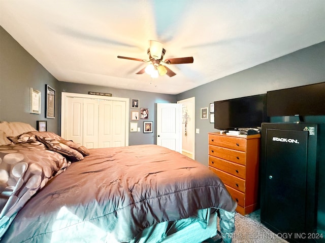 carpeted bedroom featuring ceiling fan and a closet