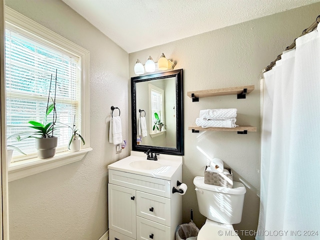 bathroom featuring vanity, a textured ceiling, and toilet