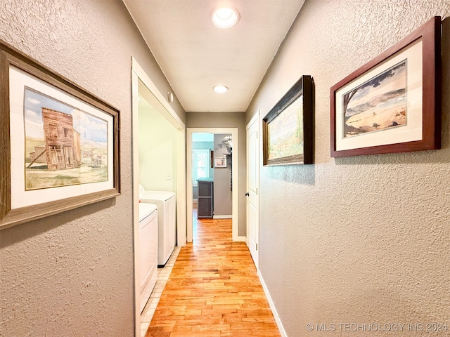 hall with light wood-type flooring and washing machine and dryer