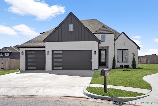 modern farmhouse style home featuring a front yard, fence, brick siding, a garage, and driveway