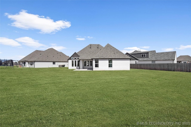 rear view of property with a yard, a patio area, and fence