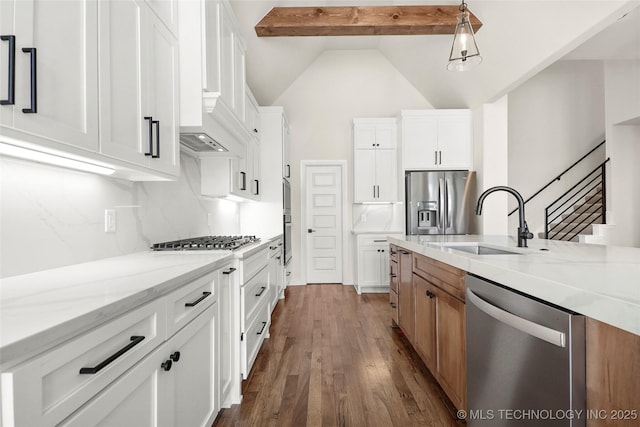 kitchen featuring a sink, dark wood finished floors, stainless steel appliances, decorative backsplash, and light stone counters