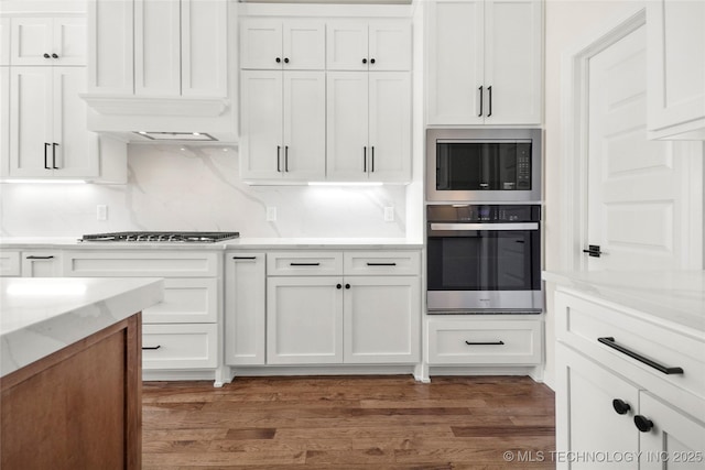 kitchen with gas stovetop, white cabinetry, stainless steel oven, and built in microwave