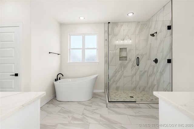 full bathroom with a freestanding tub, vanity, marble finish floor, a marble finish shower, and baseboards