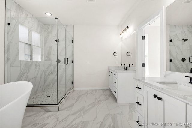 full bathroom featuring a shower stall, two vanities, marble finish floor, and a sink
