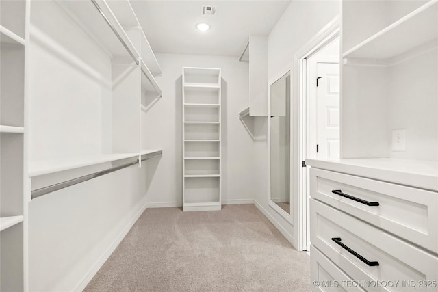 walk in closet with visible vents and light colored carpet