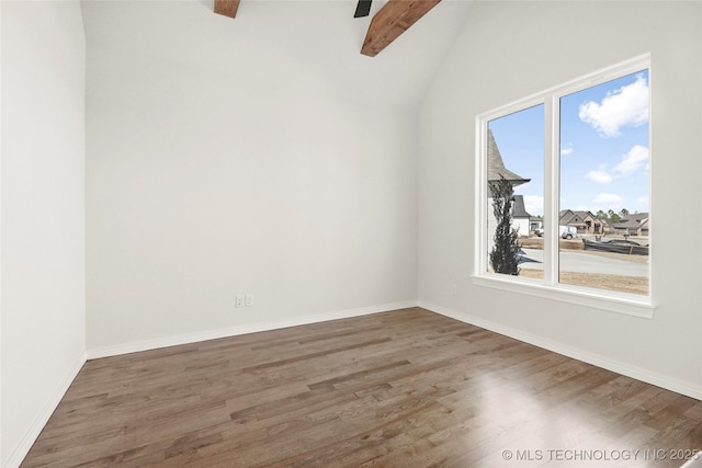unfurnished room featuring lofted ceiling with beams, baseboards, and wood finished floors