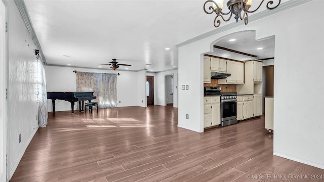 kitchen with cream cabinets, ceiling fan with notable chandelier, stainless steel stove, and hardwood / wood-style flooring