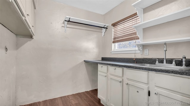 kitchen featuring dark hardwood / wood-style flooring, white cabinetry, and sink