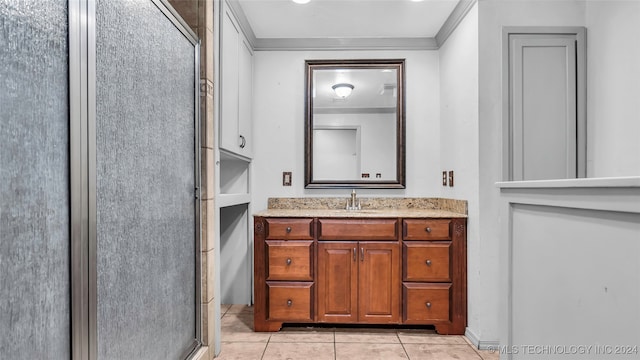 bathroom with tile patterned flooring, vanity, a shower with door, and ornamental molding