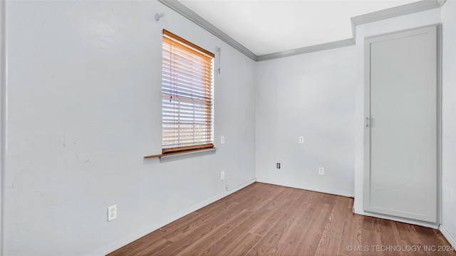 unfurnished room featuring light wood-type flooring and crown molding