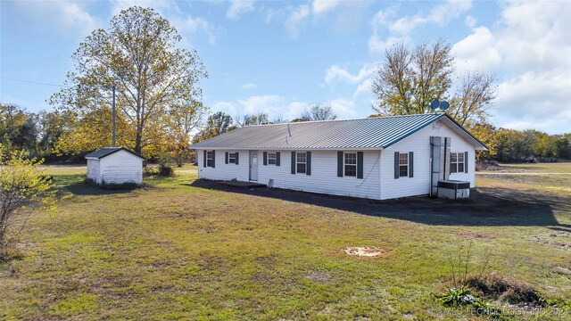 view of front of property featuring a shed and a front lawn