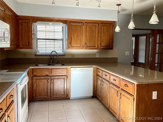 kitchen with kitchen peninsula, a healthy amount of sunlight, pendant lighting, and white appliances