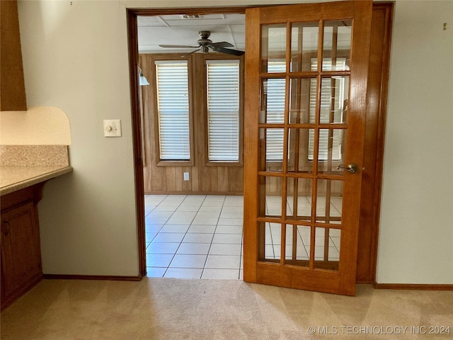 doorway to outside with ceiling fan and light colored carpet