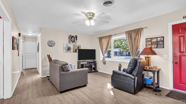 living room with light hardwood / wood-style floors and ceiling fan