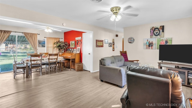 living room with ceiling fan and light wood-type flooring