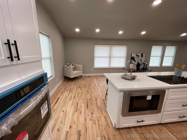 kitchen featuring white cabinetry, light hardwood / wood-style flooring, plenty of natural light, and black electric stovetop