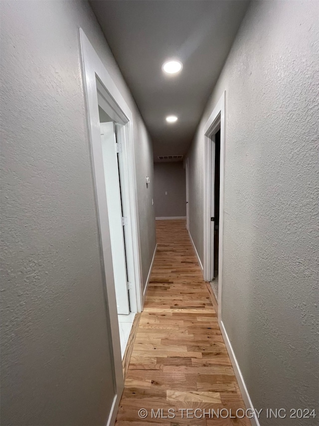 hallway with light hardwood / wood-style flooring