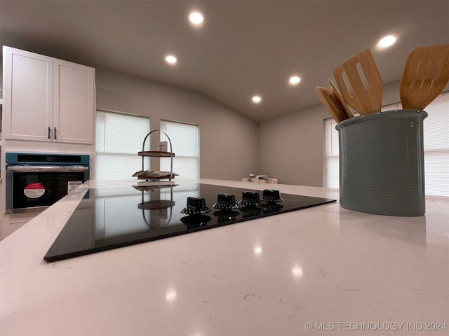 kitchen featuring white cabinets, oven, and concrete floors