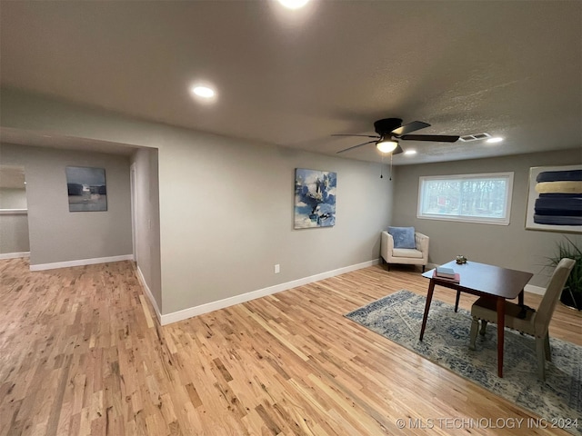 living area featuring ceiling fan and light hardwood / wood-style flooring