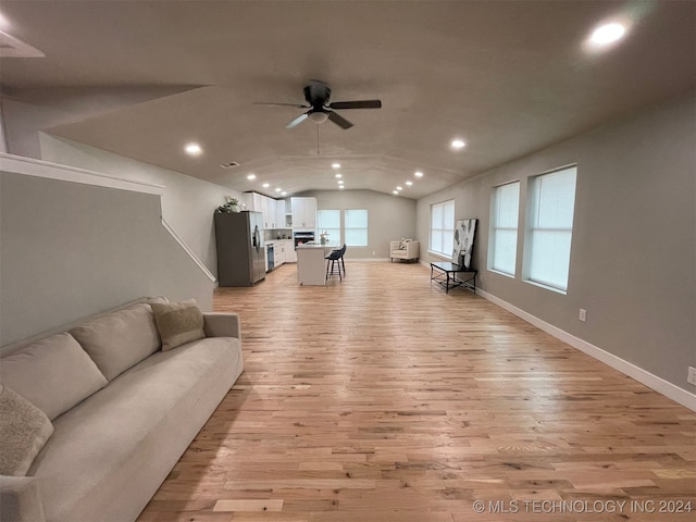 living room with light wood-type flooring, ceiling fan, and lofted ceiling