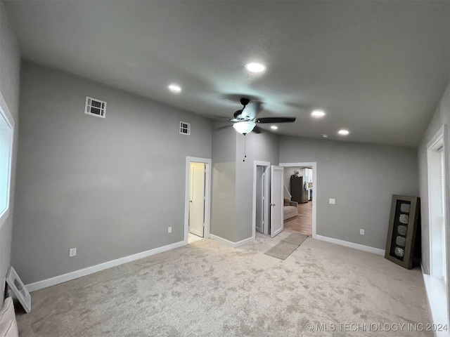 unfurnished bedroom featuring light carpet, vaulted ceiling, and ceiling fan