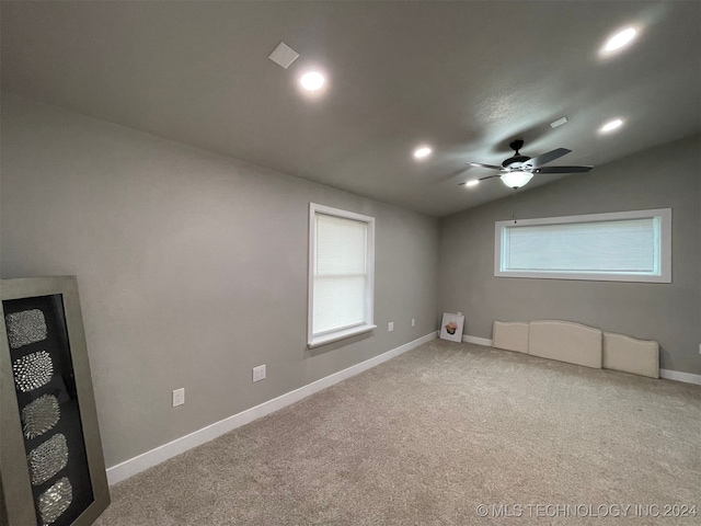 spare room featuring carpet flooring, a wealth of natural light, ceiling fan, and vaulted ceiling