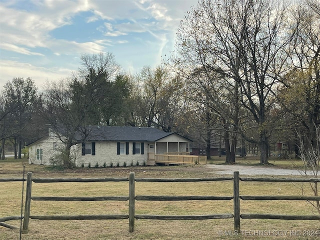 view of front of property with a deck and a front lawn