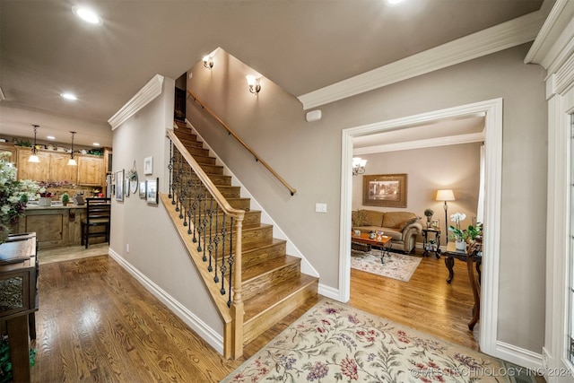 stairway featuring crown molding and wood-type flooring