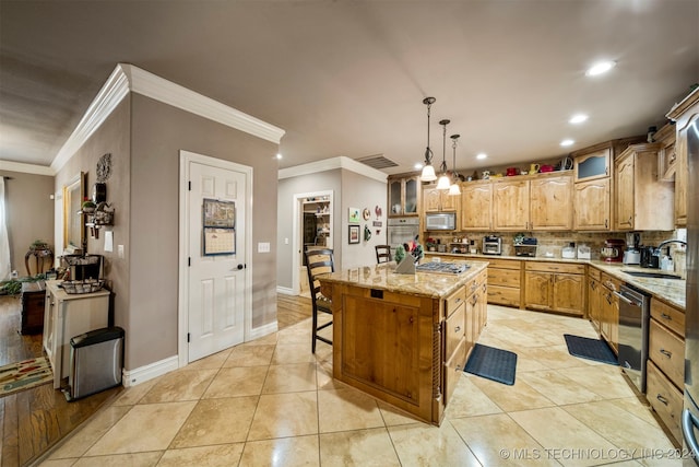 kitchen featuring a kitchen island, sink, light stone counters, and decorative light fixtures