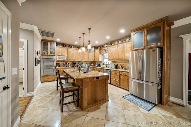 kitchen with stainless steel appliances, a center island, hanging light fixtures, and backsplash