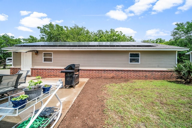 back of house with solar panels and a patio area