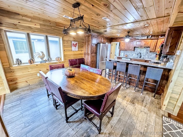 dining room with wood walls, sink, light hardwood / wood-style flooring, ceiling fan, and wood ceiling