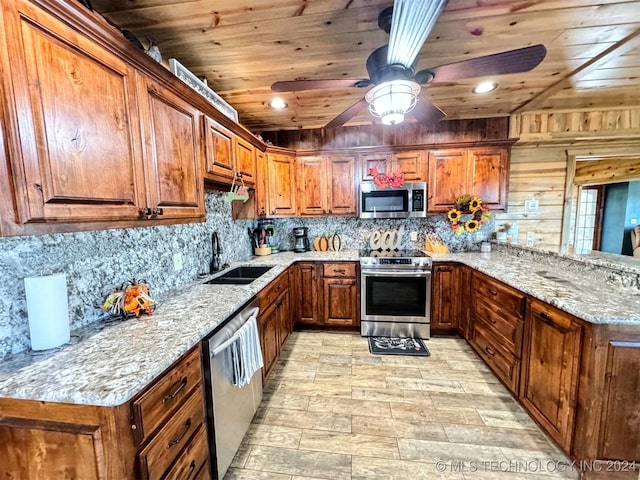 kitchen featuring light stone countertops, sink, wooden ceiling, wooden walls, and appliances with stainless steel finishes