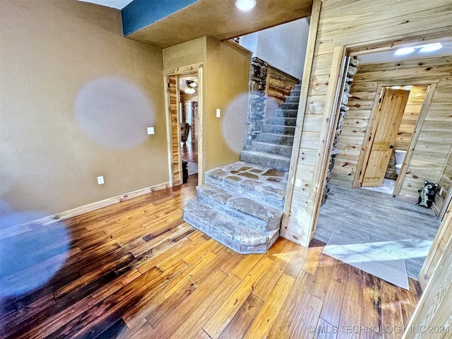 interior space with wooden walls and hardwood / wood-style floors