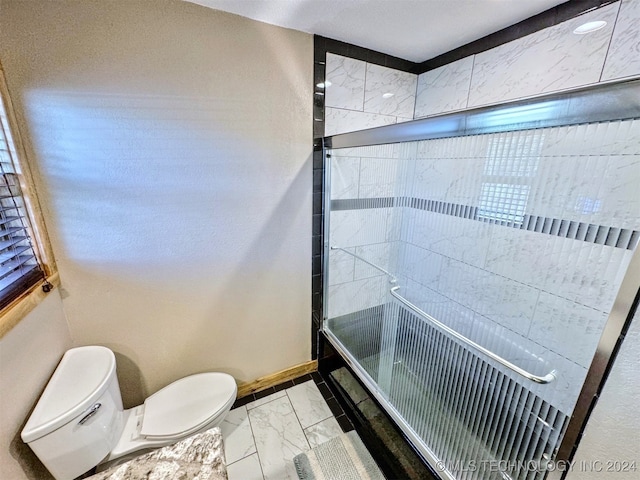 bathroom with toilet and bath / shower combo with glass door