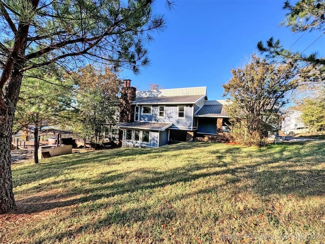 rear view of house featuring a lawn