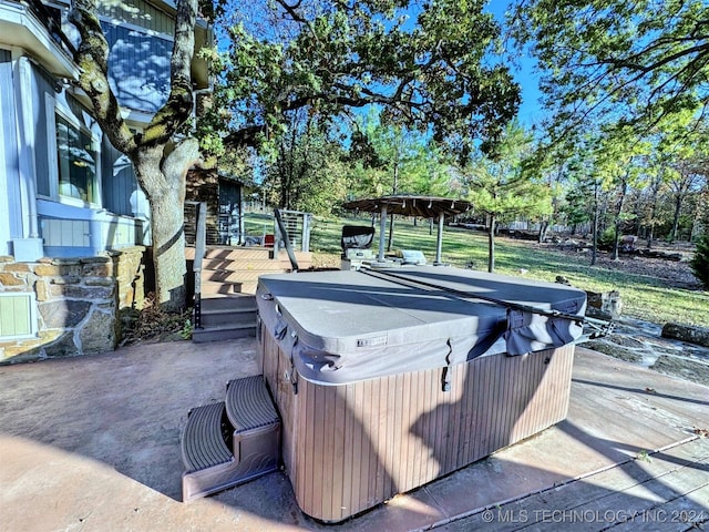 deck featuring a patio area and a hot tub