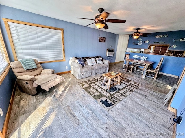 living room featuring hardwood / wood-style flooring, ceiling fan, a textured ceiling, and heating unit