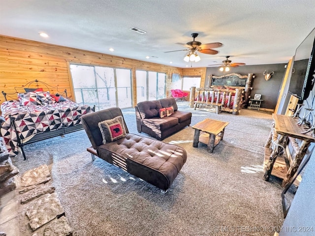 carpeted bedroom featuring a textured ceiling, ceiling fan, and wooden walls