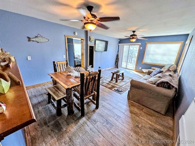 dining room with ceiling fan, wood-type flooring, and a textured ceiling