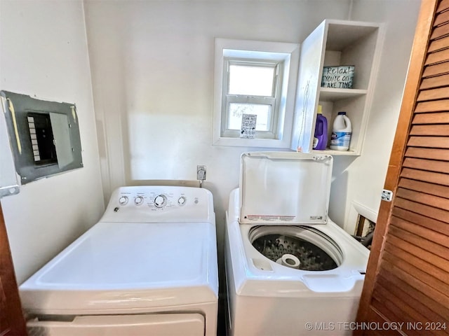 clothes washing area with washer and dryer and electric panel