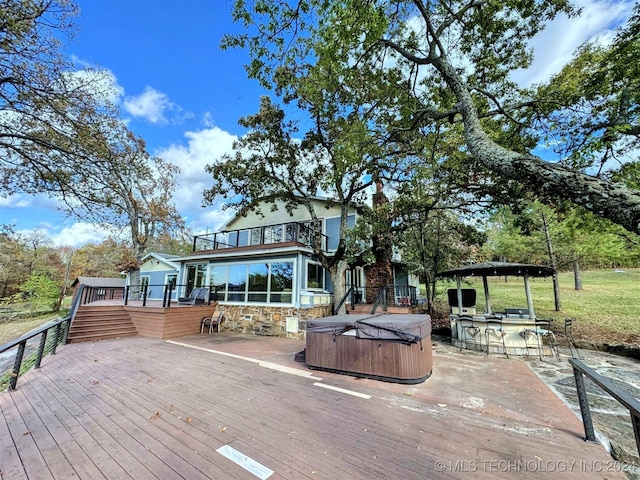 deck with an outdoor bar and a hot tub