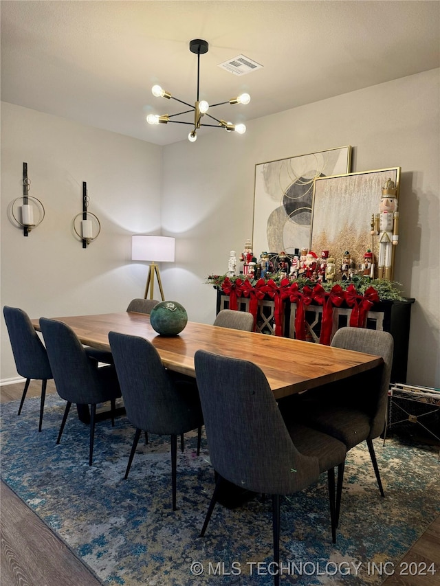 dining area with dark hardwood / wood-style flooring and a chandelier