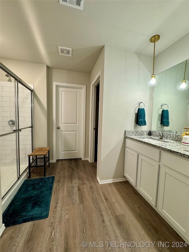 bathroom with hardwood / wood-style floors, vanity, and walk in shower