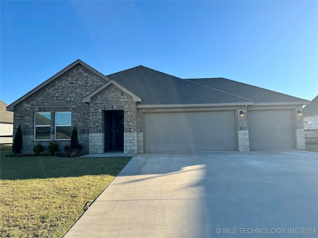 view of front of house with a garage and a front lawn