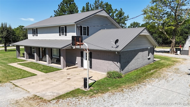 view of front of house with a front yard, a patio, and central AC