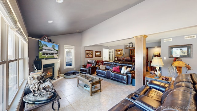 living room with light tile patterned floors, decorative columns, and lofted ceiling